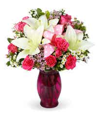 Pink roses with white lilies in a pink vase