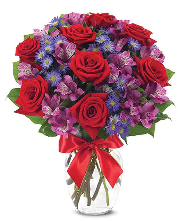 Red roses arranged with purple alstroemeria and monte casino. 
