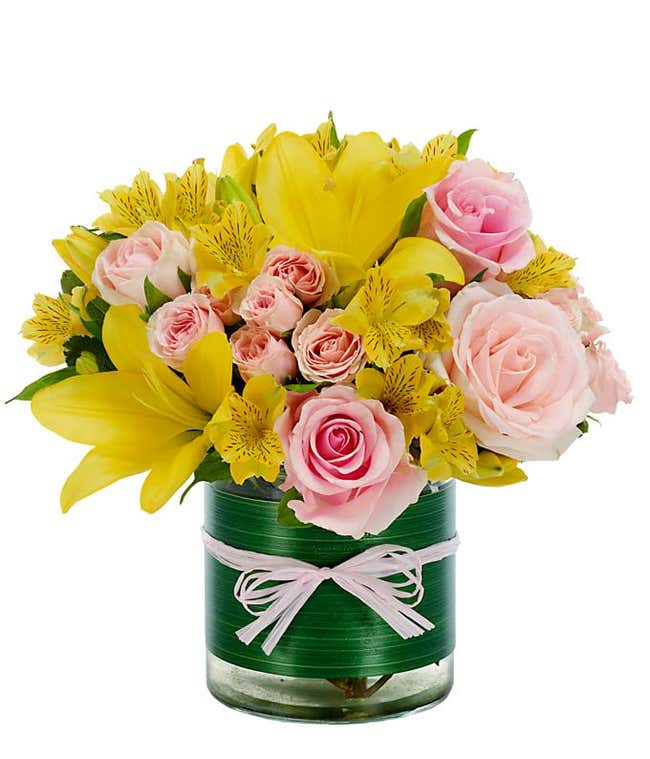 Yellow asiatic lilies, pink roses and yellow alstroemeria in circular vase