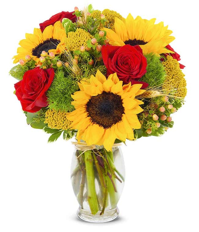 Fall flower arrangement with sunflowers, red roses and hypericum
