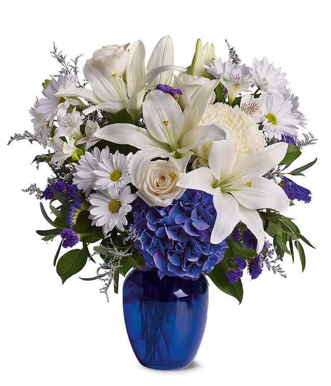 Blue hydrangea, white roses and white oriental lilies in a blue vase